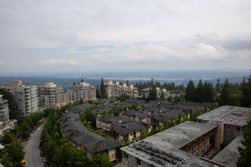 Fototapeta premium Aerial view of residential homes and buildings on top of Burnaby Mountain. Taken in Vancouver, British Columbia, Canada.
