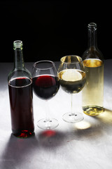 White wine and red wine in a glass on white stone background.