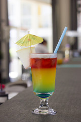 Bright cocktail with umbrella and on the bar rack