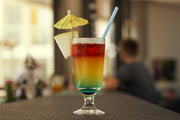 Bright cocktail with umbrella and on the bar rack