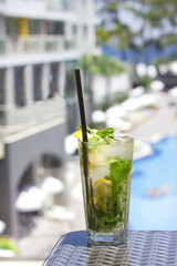 Mojito cocktail in glass on the background of the pool