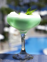 Blue cocktail in a beautiful glass with ice cream and green mint leaves