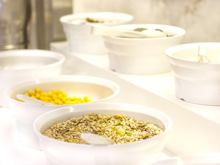 Open buffet in the hotel. Variety of corn flakes, muesli and granola on white bowls