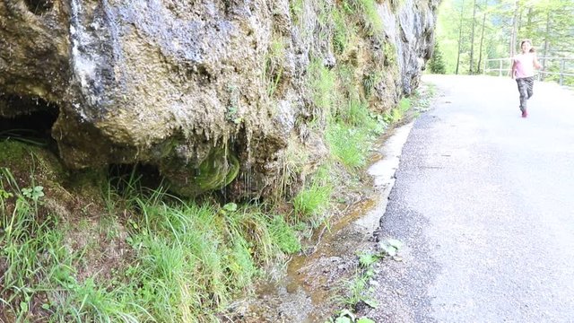 bambina beve dell'acqua fresca che esce dalla montagna