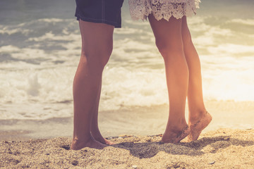 Fototapeta na wymiar Legs of young hugging couple on tropical turquoise beach