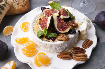 Cheese with white mold and figs, honey and nuts. Autumn sweets and fruits and wine. Delicious food for dinner. Top view