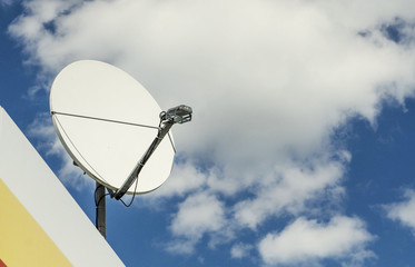 satellite dish on a background of blue cloudy sky