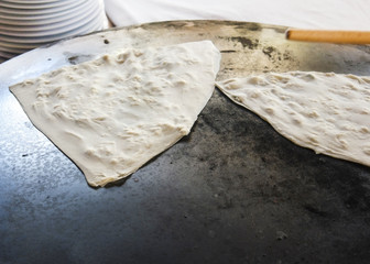 Traditional Turkish pita "gozleme" is fried on a round oven
