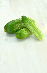 fresh cucumbers and leaves on wooden 
