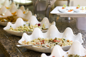 Open buffet at the hotel. Rice salad and appetizers in white bowls