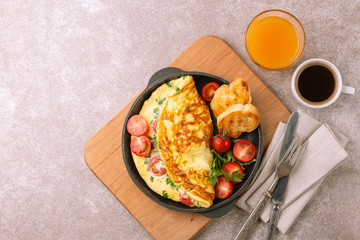 Herb omelette with tomatoes and panini toasts. Coffee. Breakfast
