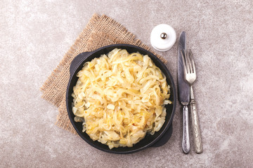 Homemade caramelized onions in frying pan. Vegetarian food..