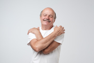 Closeup portrait confident smiling man hugging himself. I am the best concept.