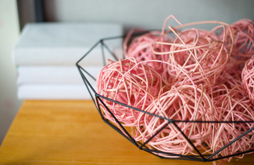 decorative pink balls of pink threads and glue and books on the shelf