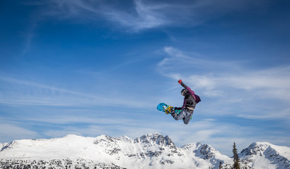 Naklejka na ściany i meble Snowboarder in mid-air grabbing the back of his board.
