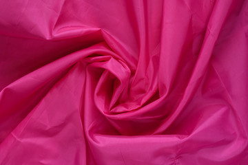 Pink Synthetic Lining Fabric with Folds. Crumpled Sheet or Clothes Background,