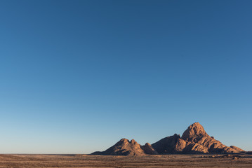 Naklejka premium Wide angle shot of Spitzkoppe, granite massive with large blue sky