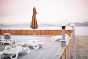 Wooden deck beach sea ocean resort sun lounger umbrella hotel pool sky sunrise.
