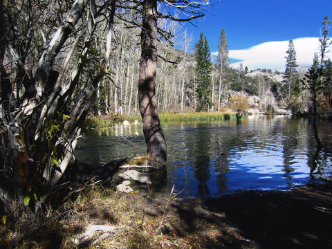 fisherman wade fishing in small lake on a sunny autumn day adjecent to Lake Sabrina near Aspendell, California