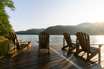 Naklejka premium Leżaki Adirondack na doku nad jeziorem