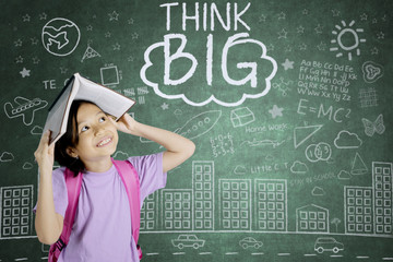 Pensive schoolgirl looking at word of think big