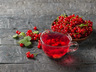 Therapeutic drink of red currant berries and fresh berries on the village table. Refreshing natural drink.