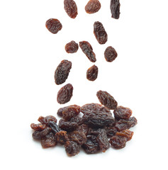 Raisins falling isolated on white background.