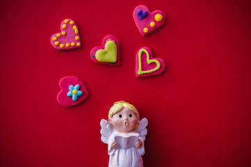 Cupid doll and heart-shaped on red background