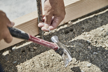 Man using a hammer to fasten down a form stake