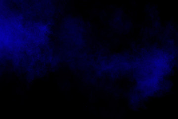 Abstract blue dust explosion on black background. Freeze motion of blue powder splash.