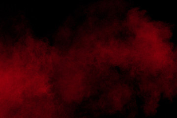 abstract red dust splattered on black background. Red powder explosion.Freeze motion of red...