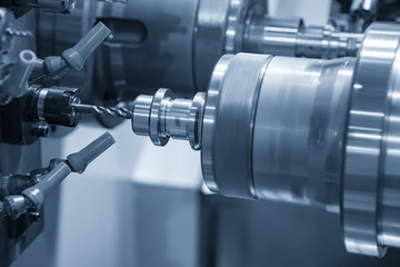 Fototapeta premium Tokarka CNC lub tokarka wykonująca gwint za pomocą narzędzia do gwintowania otworu w nierdzewnym wale. Proces produkcji w technologii Hi-Technology.