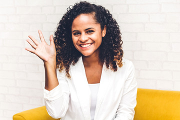 Beautiful african american black woman smiling at camera waving and saying hello to you