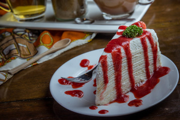 strawberry crape cake on wood table in coffee shop , dessert tasy cake