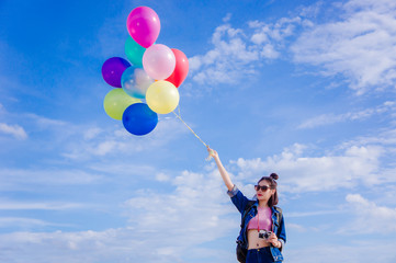 girl's travel and holds a ball of light color on a bright day sky background