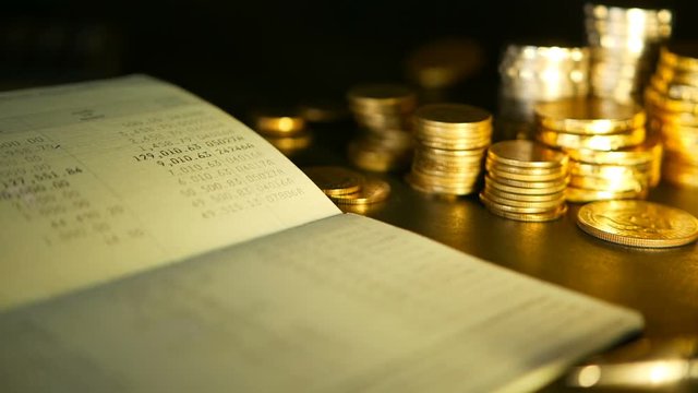 Coins stack and saving bank account passbook.concepts for mortgage and real estate investment, for saving, investment for a house, retirement, saving plan for loan, deposit. Rotating coin, soft focus