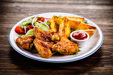 Roast chicken wings, chips and vegetables