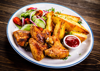 Roast chicken wings, chips and vegetables