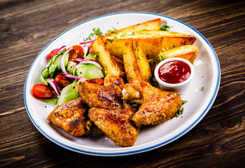 Roast chicken wings, chips and vegetables