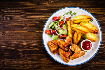 Roast chicken wings, chips and vegetables