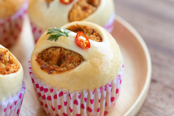 Homemade soft and sticky bun filled with dried shredded pork or pork floss and shrimp roasted chili paste on wood table. Thai style delicious bread for snack or appetizer with sweet and spicy taste.