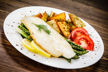 Fish dish - fried fish fillet with fried potatoes and vegetables