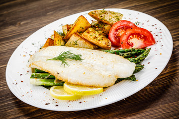 Fish dish - fried fish fillet with fried potatoes and vegetables