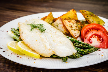 Fish dish - fried fish fillet with fried potatoes and vegetables