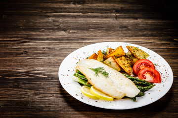 Fish dish - fried fish fillet with fried potatoes and vegetables