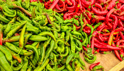 Pointed red and green peppers, in vivid contrast colours, displayed on food market.