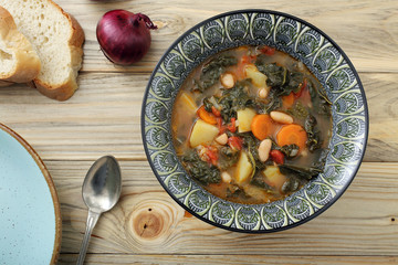 zuppa o minestra di pane con verdure su tavolo di legno