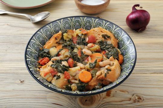 zuppa o minestra di pane con verdure su tavolo di legno
