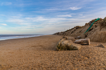 Fototapeta na wymiar North Sea coast in Newport, Norfolk, England, UK - the empty beach with some wind turbines in the background