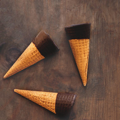 Ice cream cones pattern. Sweet Ice-cream cones with chocolate on wooden background, flat lay. Summer concept. Top view.